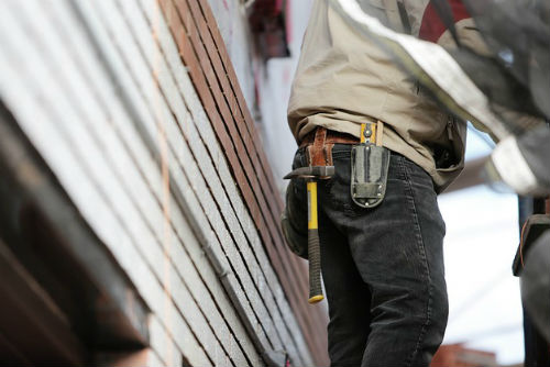 A man in a tool belt with tools hanging from it