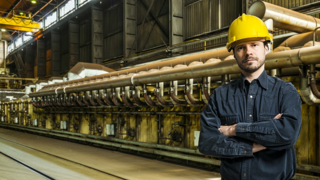 man in hard hat standing in front of machinery