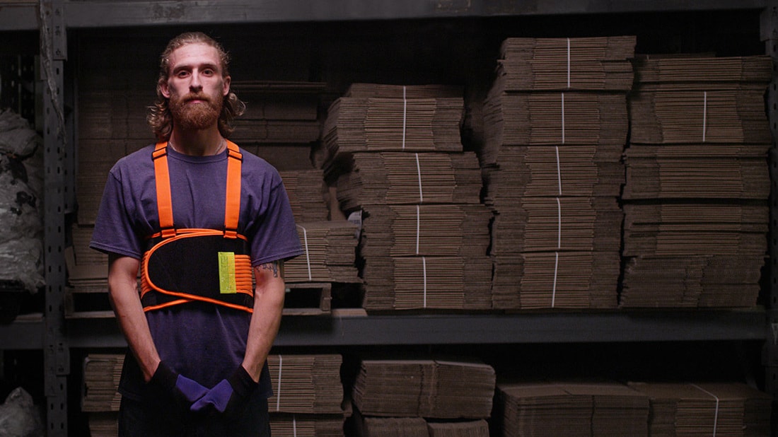 man standing in front of packing material with back brace on