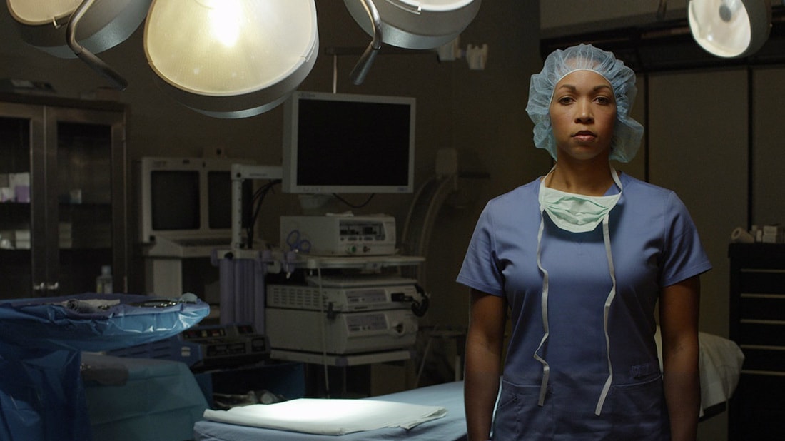 Nurse standing in front of medical equipment