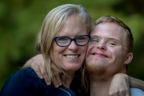 A woman hugging a mentally disabled young man