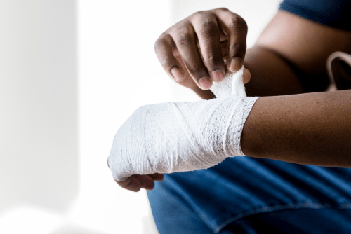 man bandaging injured hand