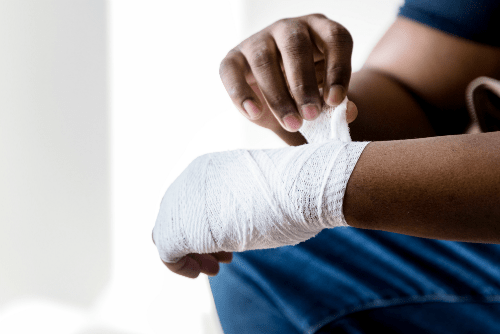 a man wrapping his injured wrist in gauze