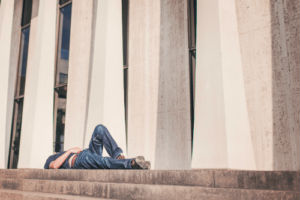 A man laying down on the steps of a Columbus Courthouse