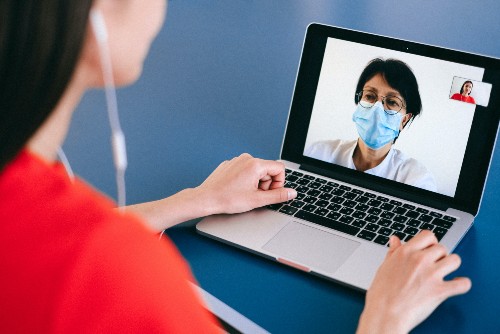 A woman talking to a doctor via zoom for her workers compensation medical check-in