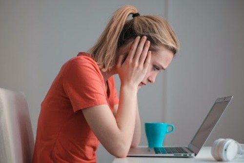 A woman staring at a computer screen trying to find a workers comp attorney in Columbus to help her file a claim.