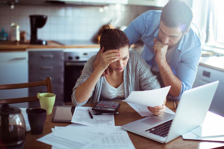 A couple looking at medical bills, concerned about their denied workers compensation claim.