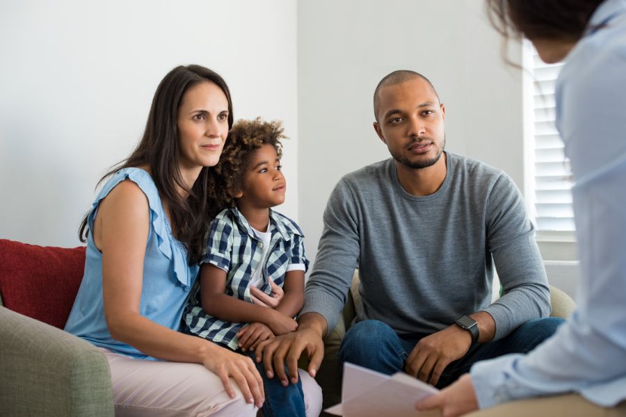 A family sitting on a couch talking to their workers comp attorney